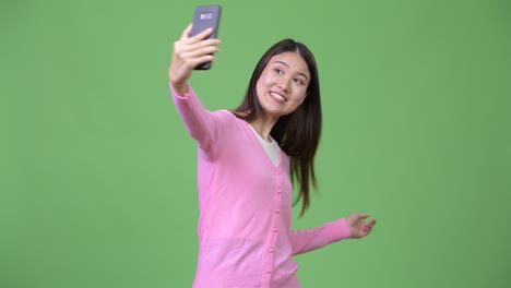 young beautiful asian woman showing phone