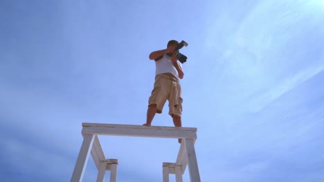 Fotógrafo-Profesional-Con-Cámara-Sobre-Fondo-De-Cielo.