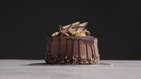 close up studio shot of freshly baked and decorated chocolate celebration cake against black background