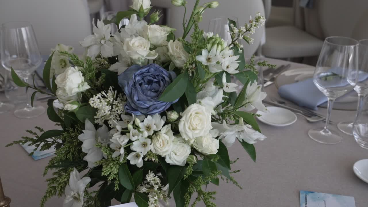 Elegant white and blue floral centerpiece on a wedding reception table