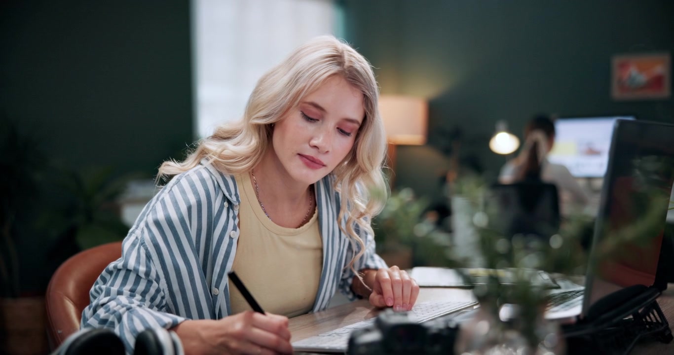 Giovane donna al lavoro su un progetto di graphic design in un ufficio moderno