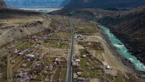 Aerial-View-Of-Valley-Floor-Beside-River-In-Skardu-With-Village-Buildings-And-Fields