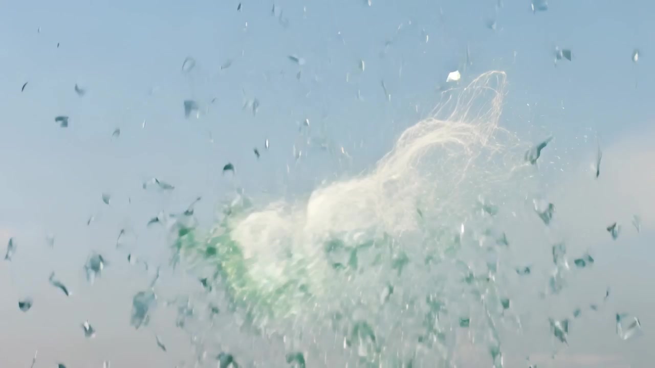 中央から噴出し、緑色の破片の雲が開けた空に光るループを形成し、漂う破片を伴う。