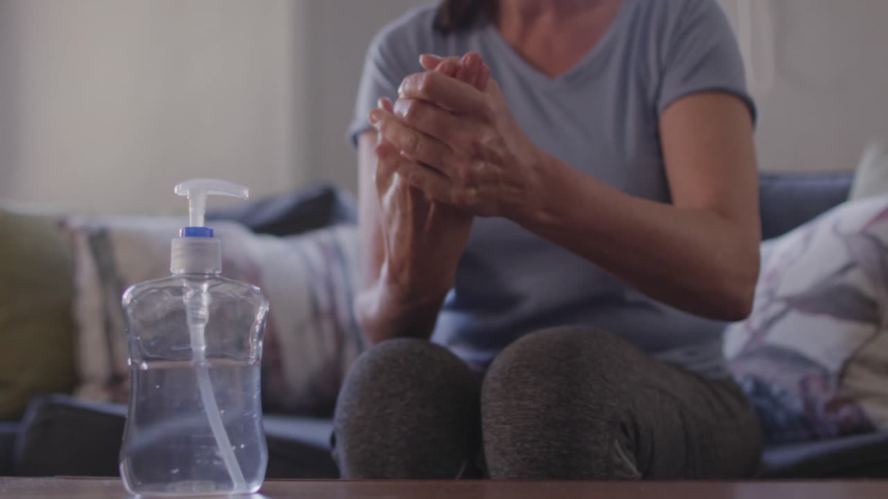 집 에서 손 을 소독 하는 여자 의 중간 부분