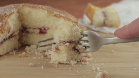 eating slice of victoria sponge cake with fork close up shot