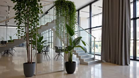 modern office lobby with indoor plants and glass staircase