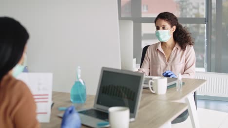 video de mujeres manteniendo las reglas de distancia social en la oficina