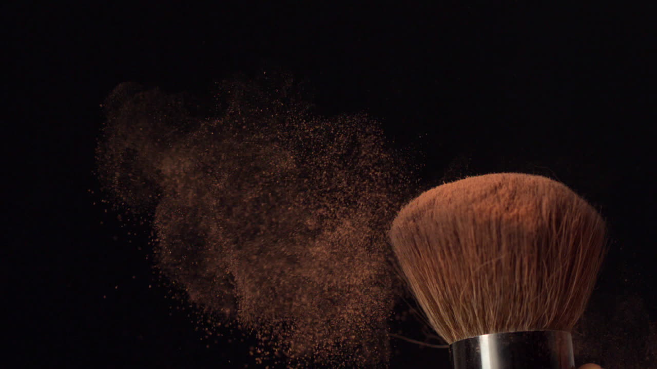 Womans finger flicking powder brush