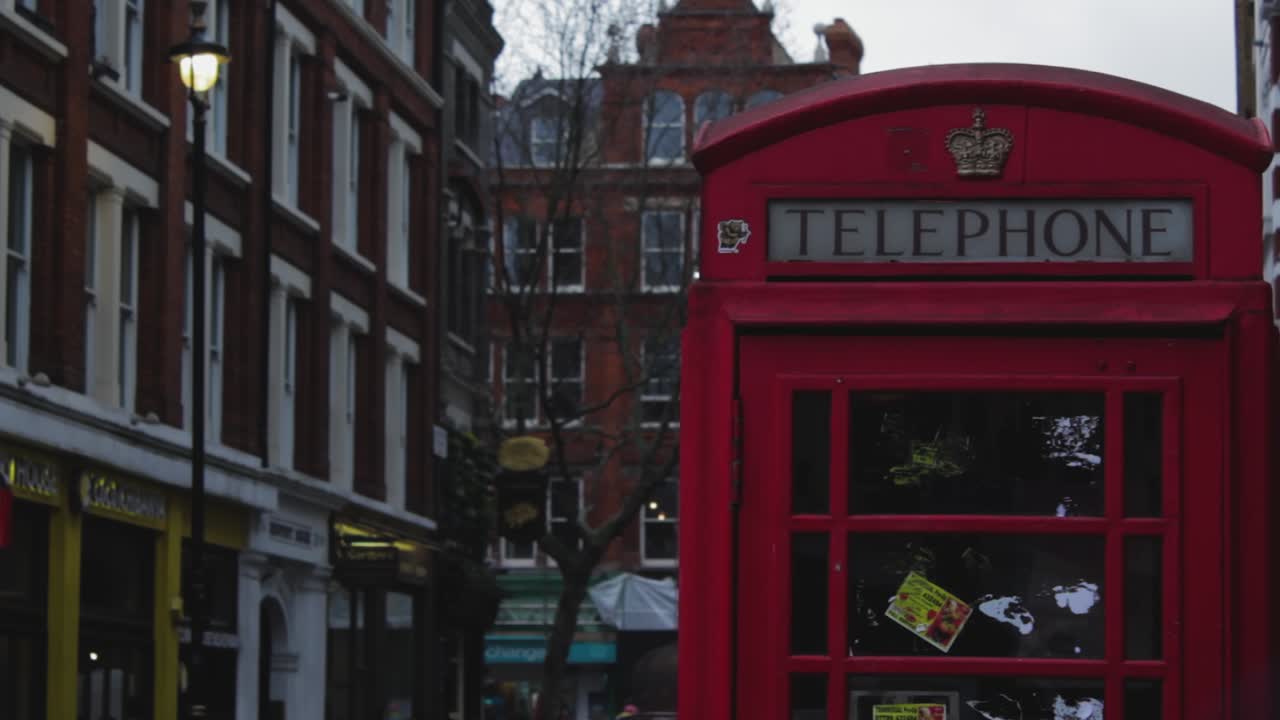 Closeup of an old historic red telephone booth in London. The typical symbol phone booth of the United Kingdom and England. A red phone booth outside of London street. A red telephone booth in London.