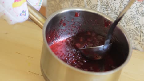 Mid-section-of-senior-woman-preparing-jam