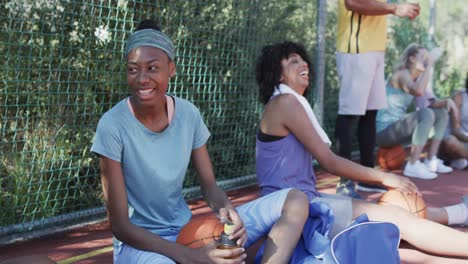 happy diverse female basketball team training with male coach on sunny court, in slow motion