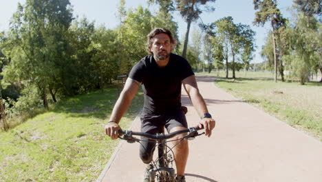 Handheld-shot-of-happy-man-with-disability-cycling-outdoor
