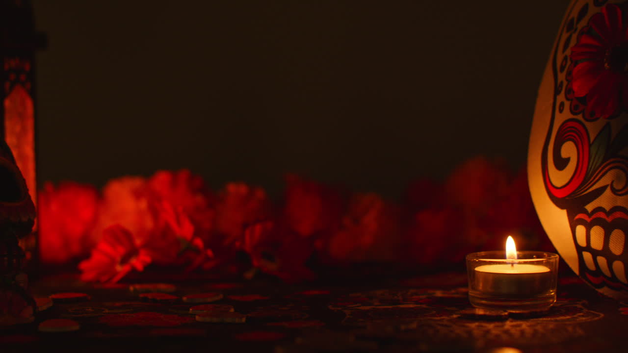 vida muerta de cráneo y máscara decorados rodeados de velas y flores celebrando la fiesta mexicana de dia de muertos o día de los muertos contra un fondo oscuro 2