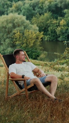 man relaxing outdoors by a river