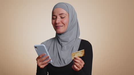 Young-woman-use-credit-bank-card-and-smartphone-while-transferring-money,-purchases-online-shopping