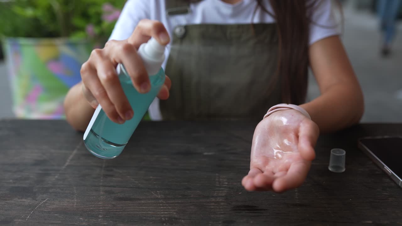 mujer aplicando desinfectante para manos