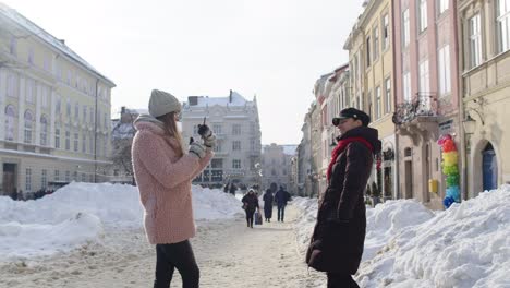 two friends having fun in the snow during winter