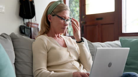 smiling senior woman using laptop at home, enjoying online holiday shopping