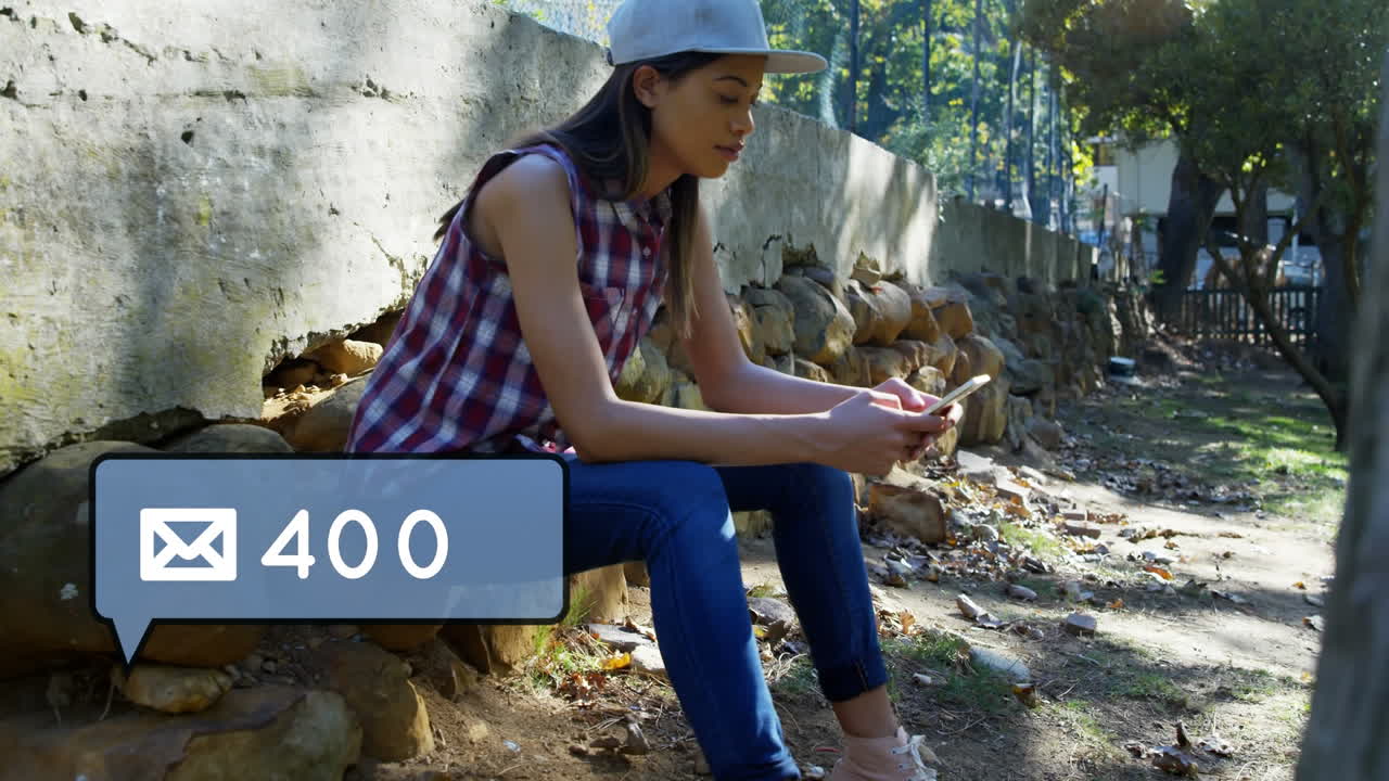 sobre con icono de burbuja de mensaje y mujer usando teléfono móvil