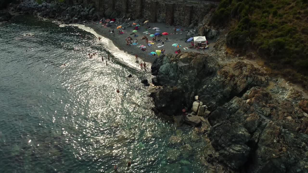 Beach with rocks, sea, and people