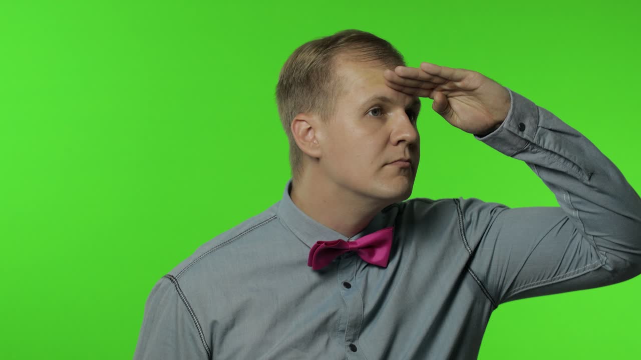 눈 위에 손을 들고, 멀리 멀리 쳐다보며 주의 깊게 누군가를 찾고 있는 남자