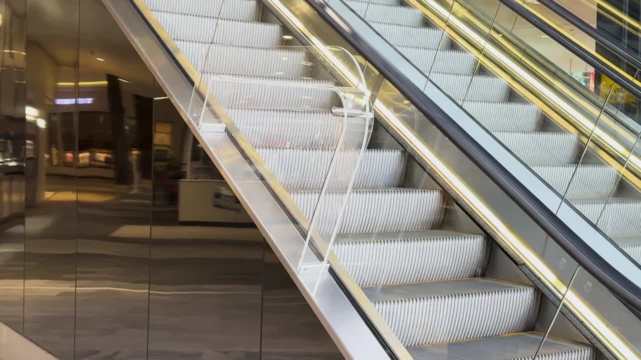 Detailed view of escalator steps and handrails in a modern indoor setting.