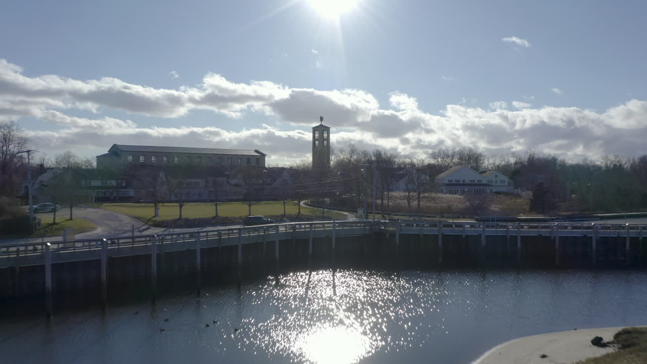 The camera flies very low through the Rock Harbor marina. It flies past docked fishing boats and other vessels that are in the marina.