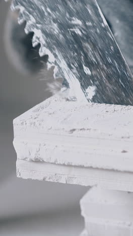 professional painter in gloves saws white gypsum plasterboard fast and takes cut part close view