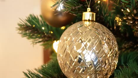 cerca de un ornamento de navidad de oro en un árbol de navidad