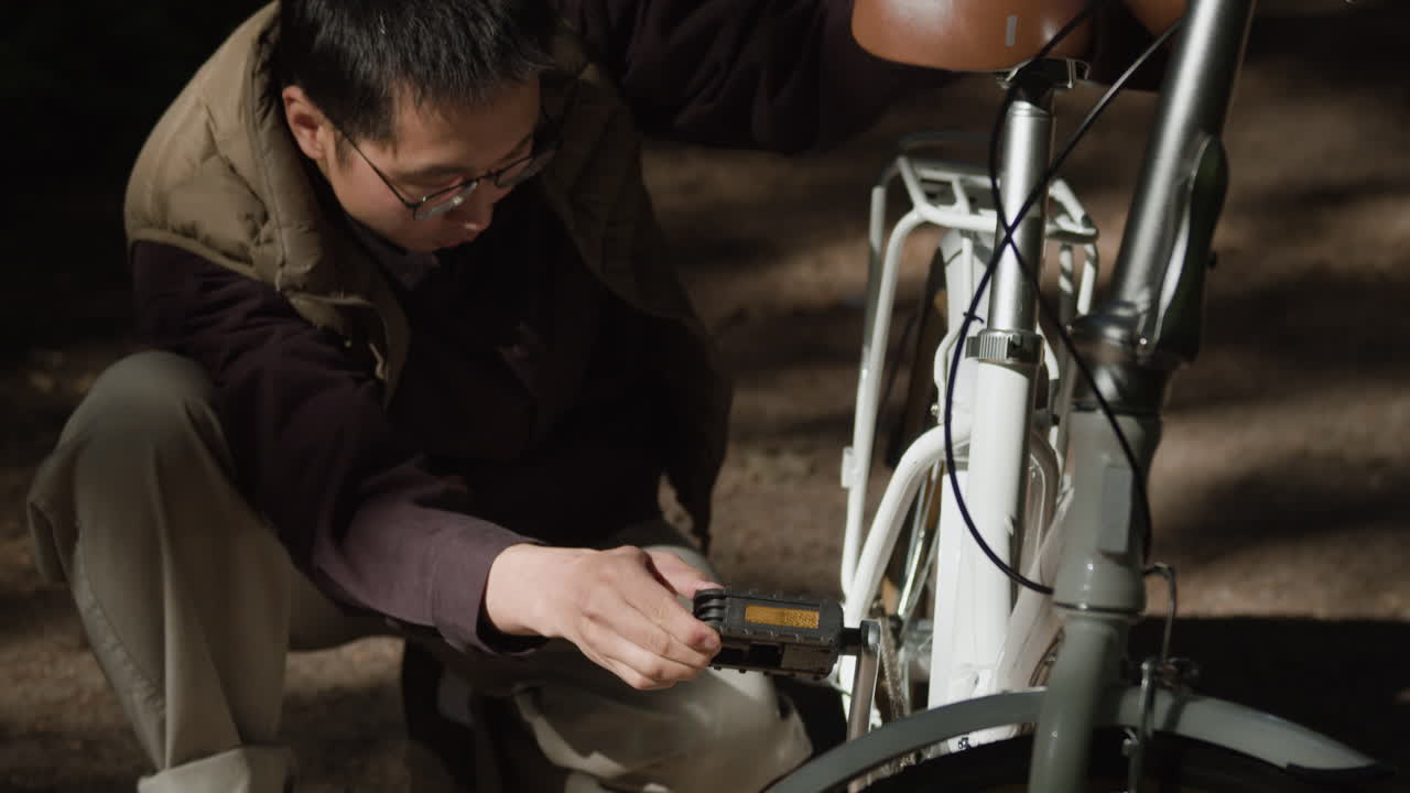 Man fixing bicycle pedal