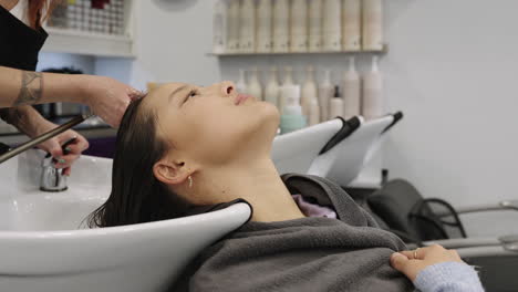 woman getting hair washed at salon