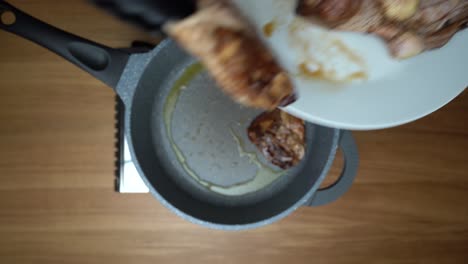 poniendo patas de pollo y muslos de pollo en una sartén caliente