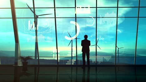 silhouette of a man standing in his office on the background of wind power stations and infographics.