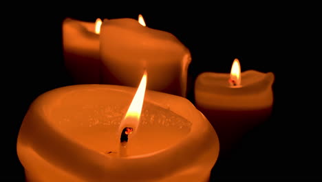 Beautiful-orange-lit-candle-on-black-background-on-slow-motion-time