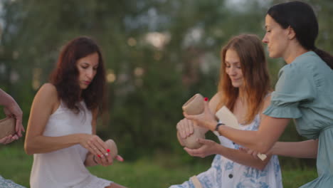 Las-Mujeres-Jóvenes-Esculpen-En-Arcilla-Escuchan-Al-Maestro-Comunicarse-Al-Aire-Libre.-El-Maestro-Explica-La-Técnica-Correcta-De-Modelado.-Actividad-Creativa-Pasatiempos-Clase-Magistral-Formación