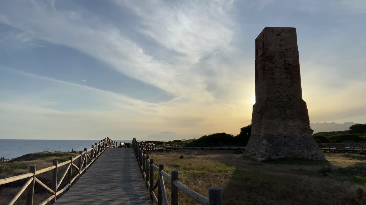 Walking on a wooden path on a southern Spanish beach in Marbella, with stormy skies.