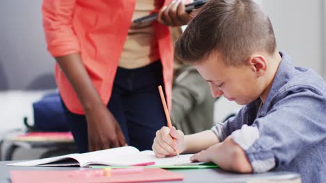 diversas maestras y escolares en los escritorios en el aula de la escuela