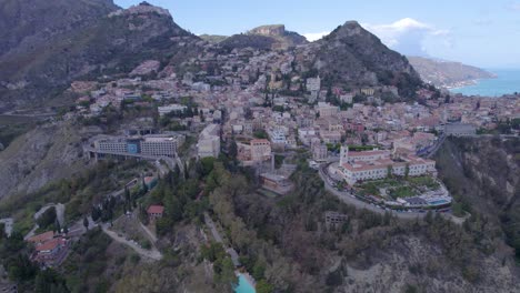 Amplia-órbita-Aérea-Sobre-Taormina,-Sicilia,-Italia,-Un-Lado-Sur-De-La-Ciudad-Sobre-El-Volcán.