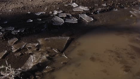 Toma-Estática-De-Trozos-De-Hielo-Congelados-En-La-Parte-Superior-De-La-Piscina-De-Barro-Durante-La-Madrugada