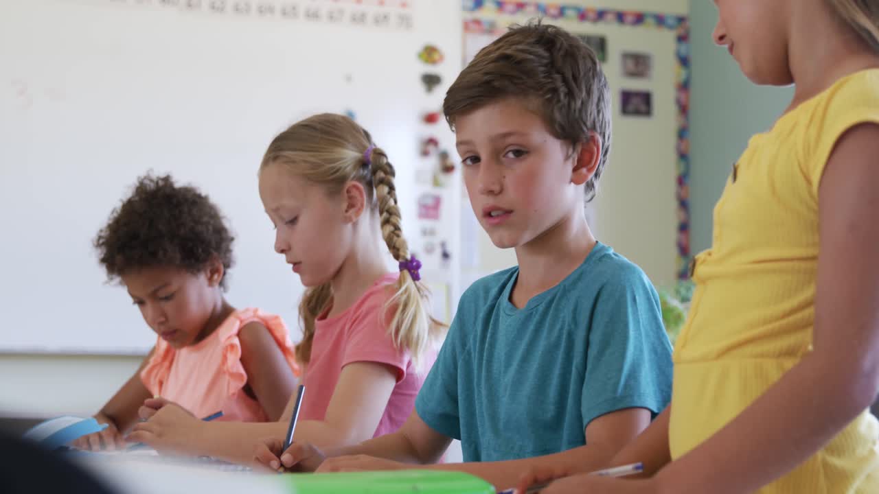 Boy smiling while studying in the class