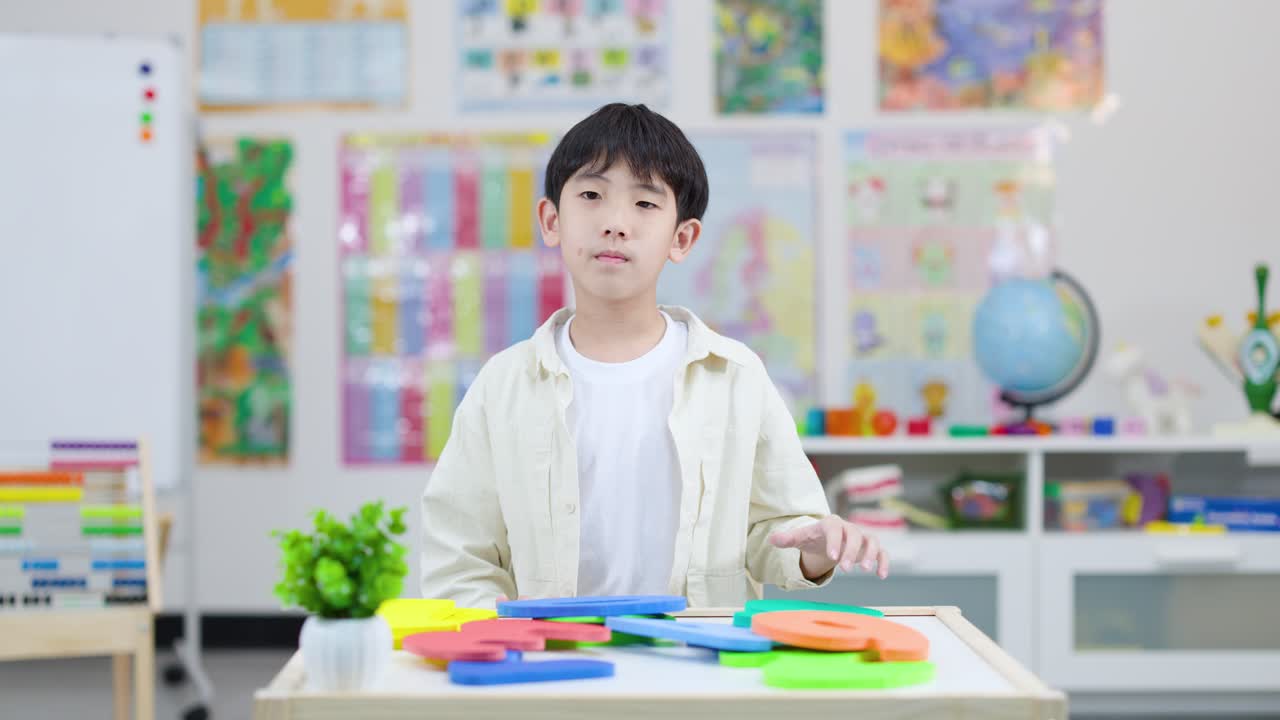 明るい教室で、元気な小学生が大きな発泡スチロールの数字の5を誇らしげに持っています。