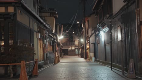 a dimly lit alley in kyoto at night, lined with traditional buildings and glowing lanterns, creates a moody and atmospheric scene in the historic city.