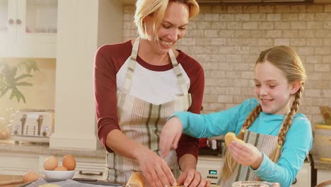 Smiling-mother-and-daughter-wearing-apron-arranging-unbaked-cookies-4K-4k