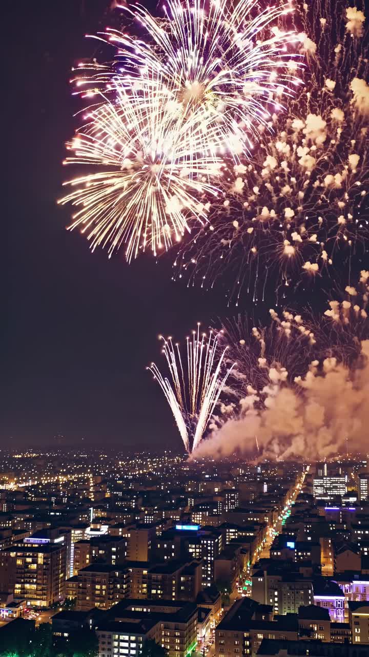 Colorful fireworks bursting over a vibrant city skyline at night, illuminating the urban landscape and creating a lively, festive atmosphere filled with joy and excitement