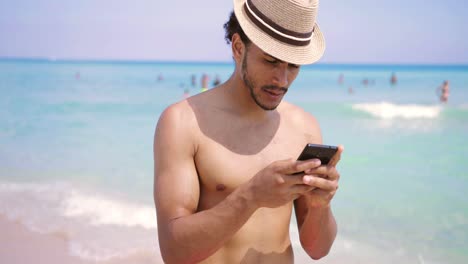 hombre sonriente enviando mensajes de texto con un teléfono inteligente