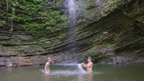 niños salpicando en una piscina de cascada