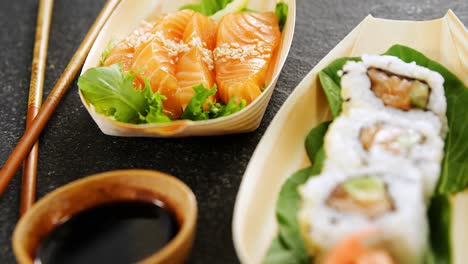 sushi en un plato en forma de barco con palillos