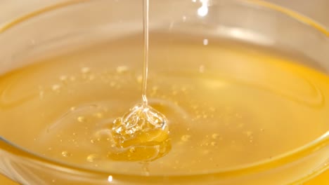 Pouring and stirring honey in a glass bowl
