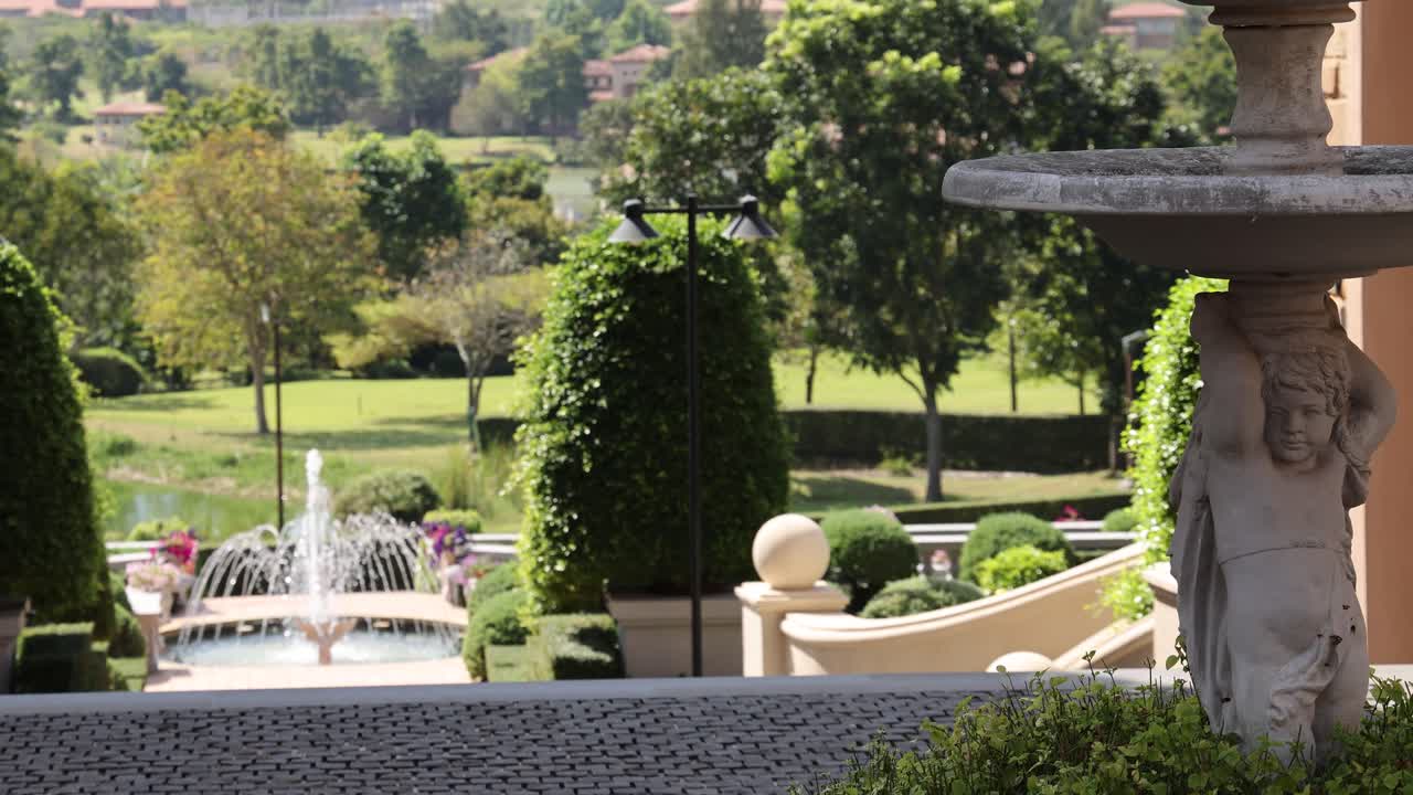 el lapso de tiempo de una fuente en un jardín exuberante y formal