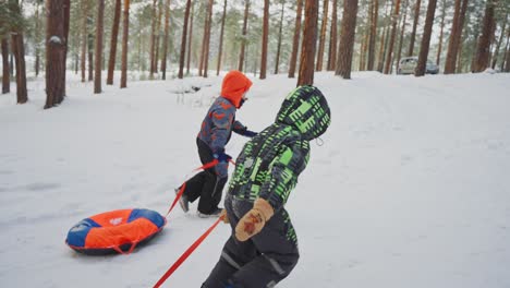 kids snow tubing in the forest